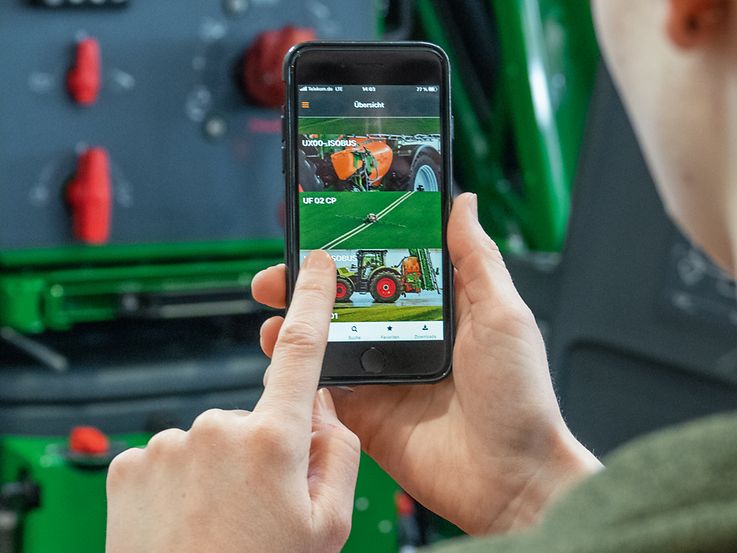 Billede af en person der holder en mobil med amazones app åben